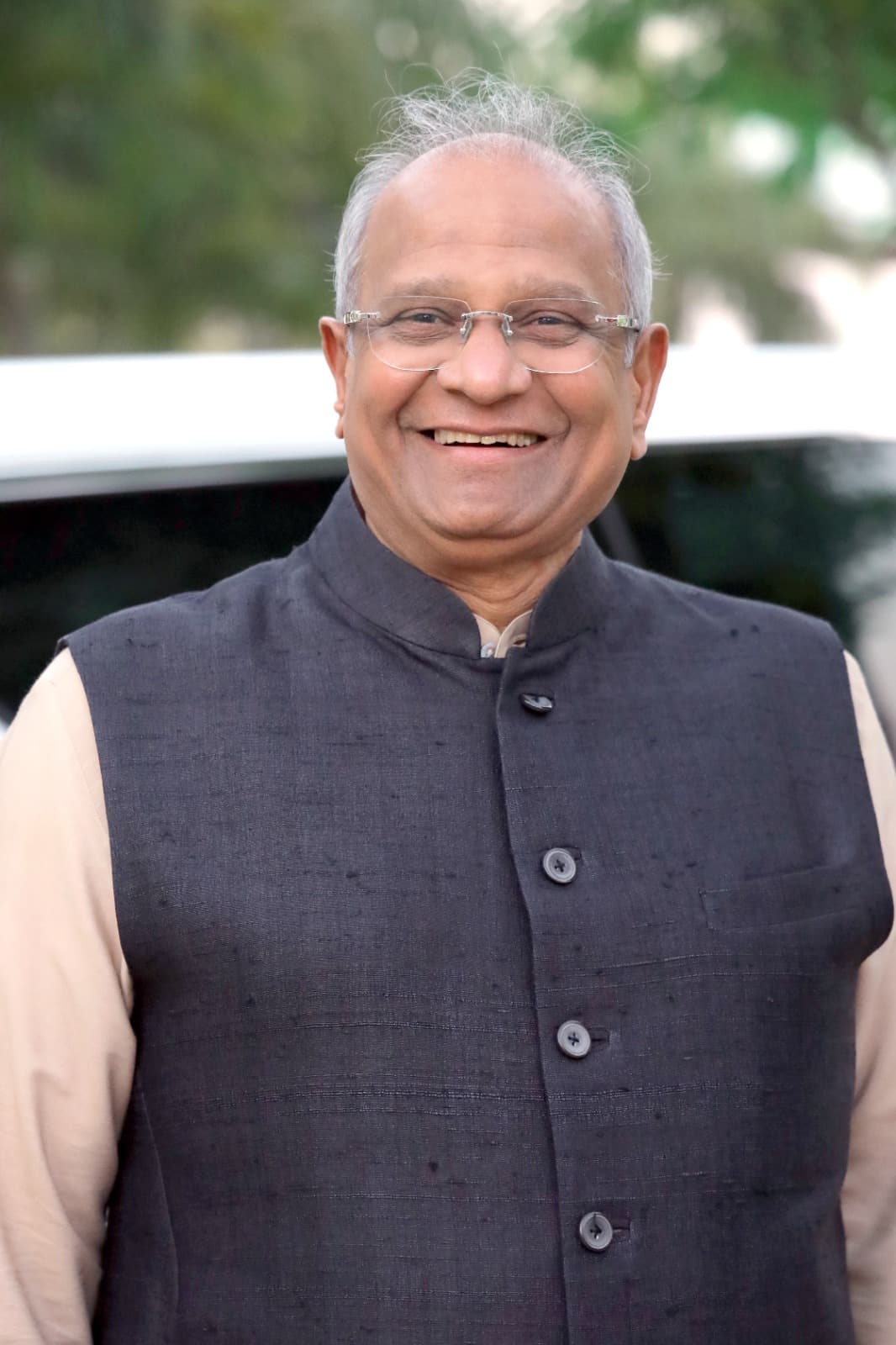 Bhupeshbhai smiling outdoors beside a car